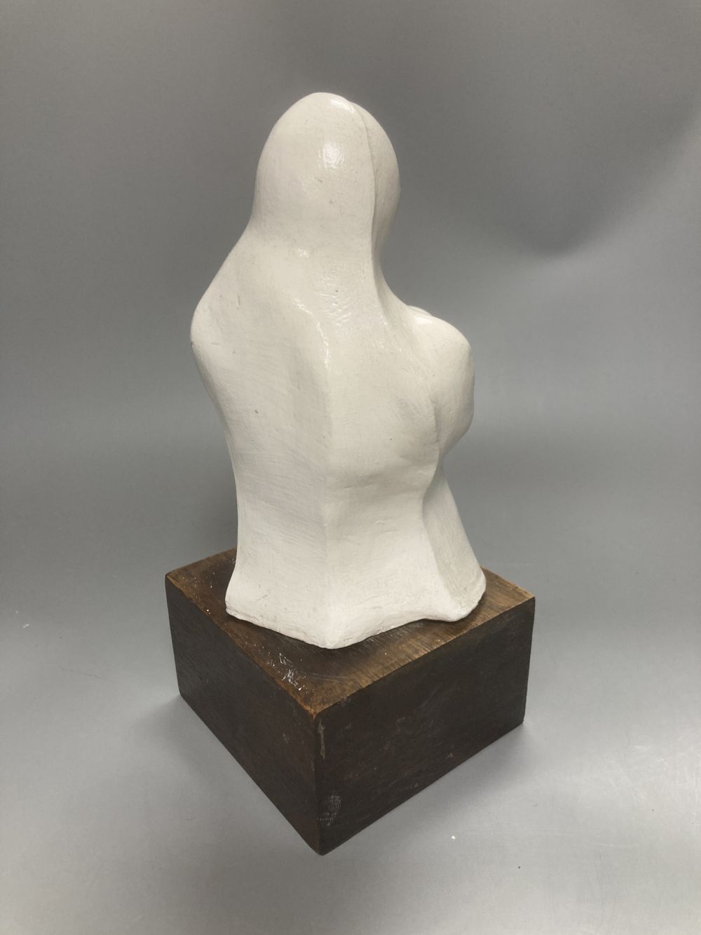After Henry Moore, two related figural sculptures in wood and plaster, 31cm, white composition, 28cm